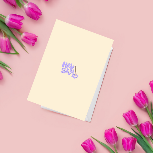 Back of the greeting card on a darker beige background with the Mew Studio logo in the middle