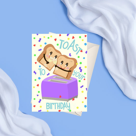 a light beige card with colorful confetti on the background and two pieces of toast , toasting with champagne glasses . the toast is coming out of a purple toaster and it has the text toast to your birthday around it.