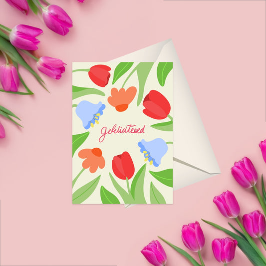 A vibrant Dutch ‘Gefeliciteerd’ card with colorful flowers emerging playfully from the side of the card. The cheerful design is set on a white background with elegant typography, perfect for any happy occasion. Handmade and includes matching white envelope